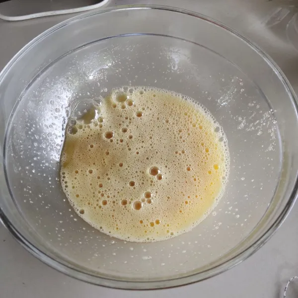 Campur gula pasir dan telur, aduk menggunakan whisk hingga gula larut.