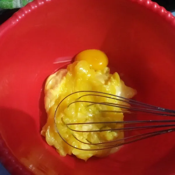 Kocok mentega mix margarin dan kuning telur menggunkan pengocok (whisk) selama 2 menit