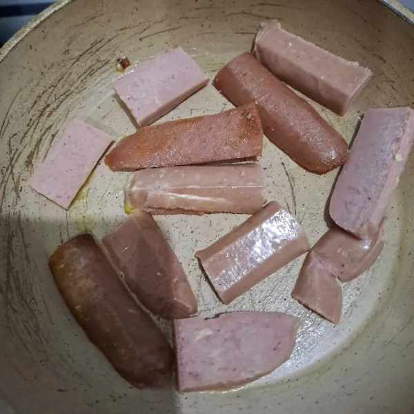 Olesi telfon dengan margarin lalu panggang sosis.