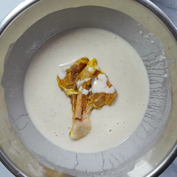 Siapkan wadah lain. Masukkan tepung ayam krispi instan dan secukupnya air, aduk rat a(adonan tepung basah kental sedang). Masukkan paha ayam yamg sudah dimarinasi. Balut paha ayam dengan adonan basah hingga terbalut rata. Angkat.