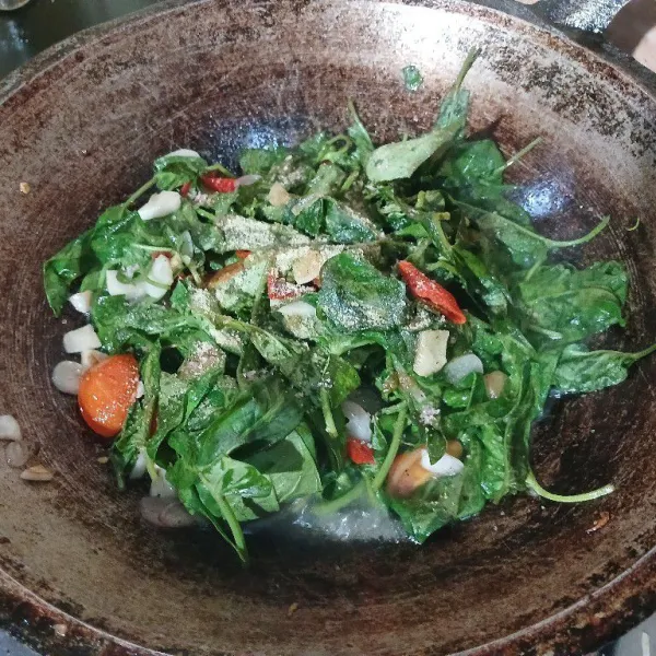 Aduk rata, beri garam dan kaldu bubuk. Aduk rata, masak hingga kangkung matang lalu koreksi rasa.