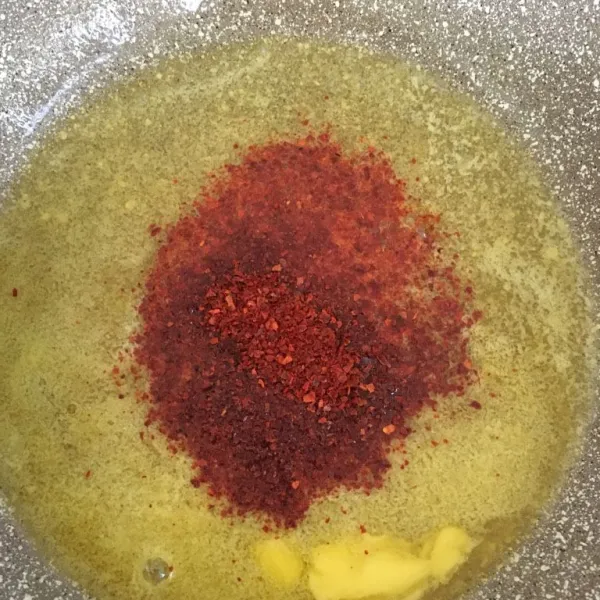 Lelehkan butter, masukkan cabai bubuk lalu aduk rata. Masak dengan api kecil hingga meletup kemudian sisihkan.