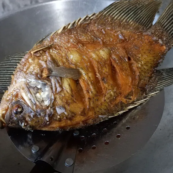 Bersihkan ikan mujair, kemudian goreng sampai matang dan garing