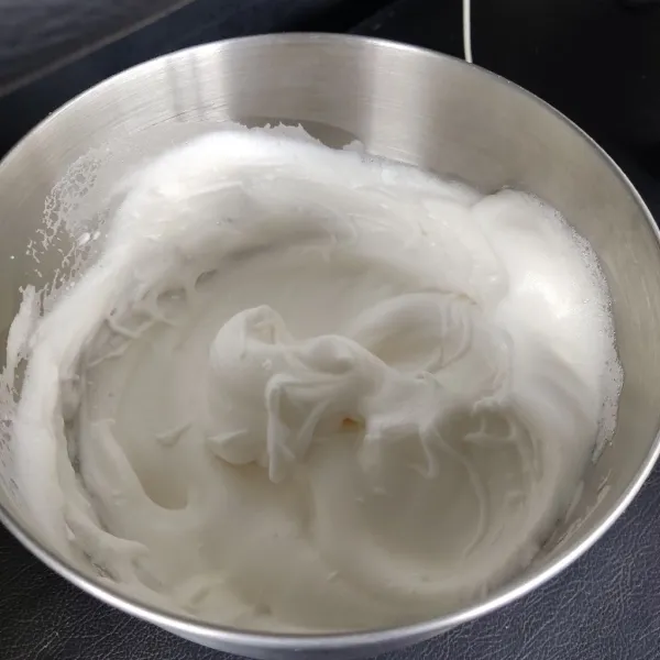 Mixer putih telur hingga berbuih, masukkan jeruk nipis dan mixer lagi hingga berbusa. Tuang sisa gula secara bertahap hingga adonan berjambul