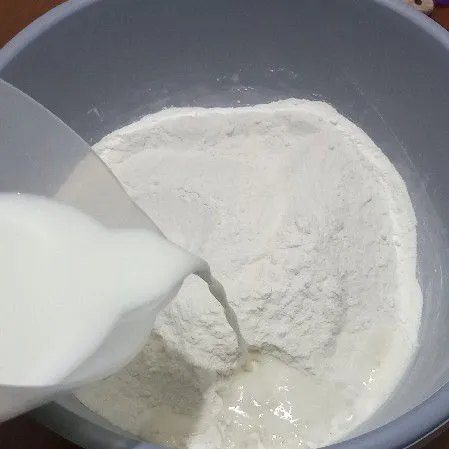 Campur tepung terigu, ragi instan dan gula pasir, tuang susu cair secara bertahap lalu uleni sampai setengah kalis.