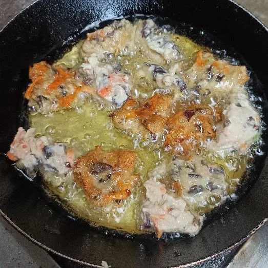 Goreng dengan bantuan sendok ke dalam minyak.