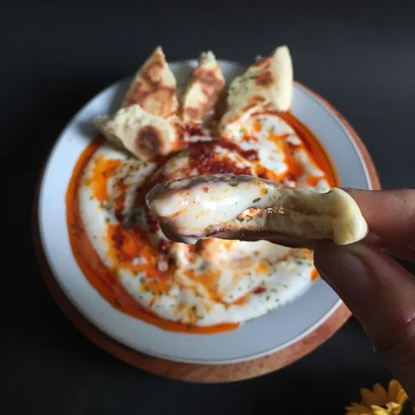 Tata yogurt base, poached egg, saos butter, roti, taburi parsley lalu ambil 1 bagian roti dan cocol ke saos. Santap selagi hangat.