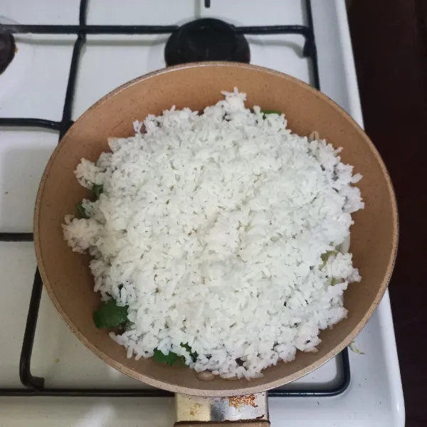 Masukkan nasi pada wajan, aduk rata.