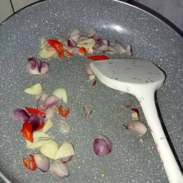 Tumis bumbu iris dengan minyak hingga harum.