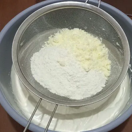 Masukkan tepung terigu, susu bubuk, garam dan vanili sambil diayak, mix sebentar saja dengan speed rendah.