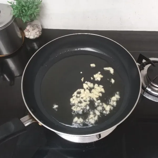 Panaskan 3 sendok makan minyak, masukkan bawang putih, tumis hingga harum dan layu.