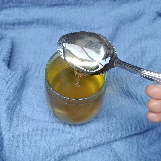 Tambahkan madu murni ke dalam gelas.