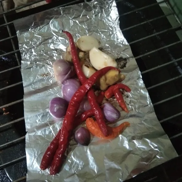 Bakar bawang merah, bawang putih, cabe merah, cabe rawit dan kencur di atas kompor hingga bau langu hilang.