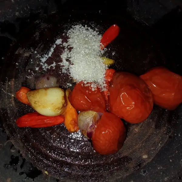 Goreng tomat, cabai dan bawang hingga matang kemudian tiriskan. Di atas cobek tambahkan gula, terasi, garam dan kaldu jamur.