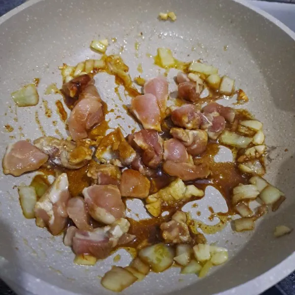 Tumis bawang putih dan bawang bombay sampai harum dan matang lalu masukkan ayam yang telah dimarinasi.