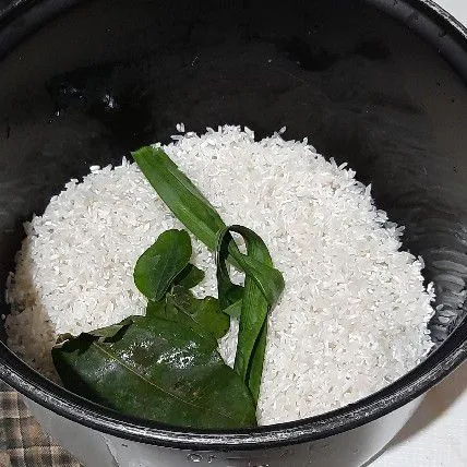 Cuci bersih beras tambahkan daun pandan, daun jeruk dan daun salam.