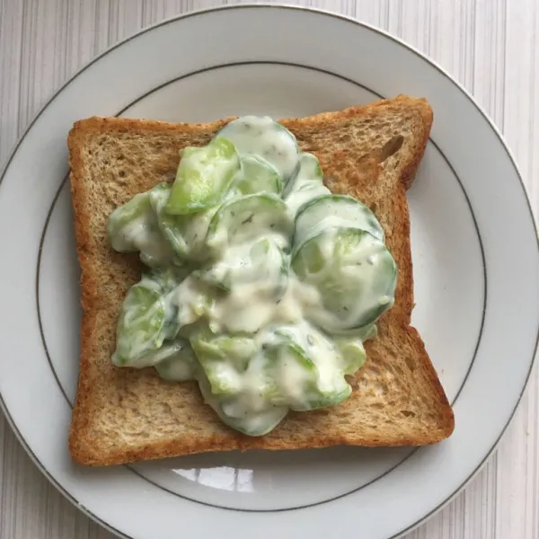 Pindahkan roti ke wadah, tambahkan salad timun yogurt.