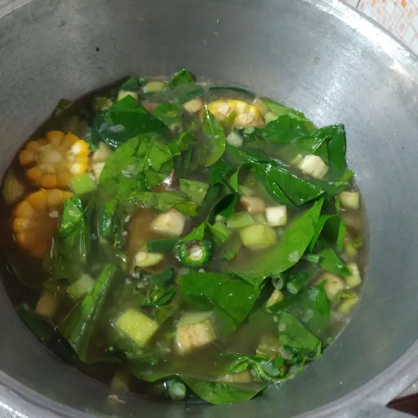 Masukkan jagung dan labu, setelah setengah matang masukkan kacang panjang, terong, daun melinjo dan cabe hijau.