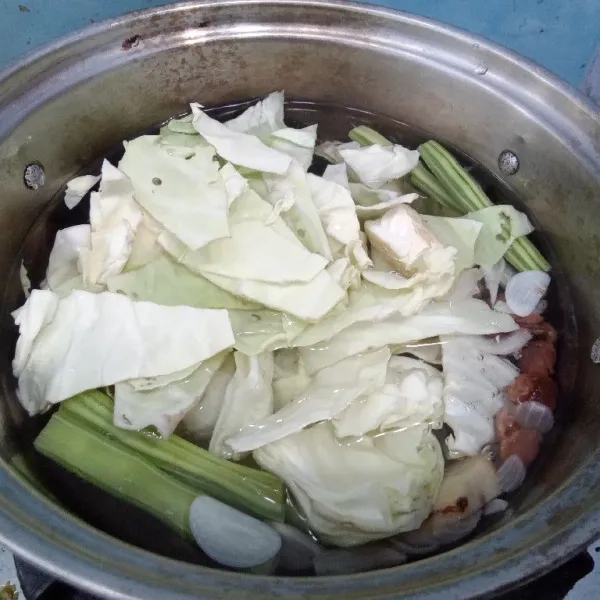 Tambahkan kubis ke dalam panci. Masak hingga matang, matikan kompor. Tambahkan gula pasir dan garam.