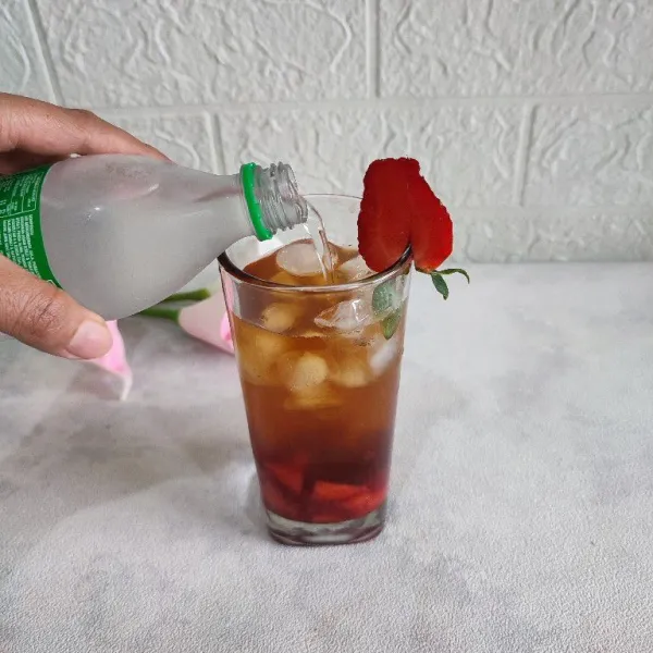 Tuang air soda lemon hingga gelas penuh.