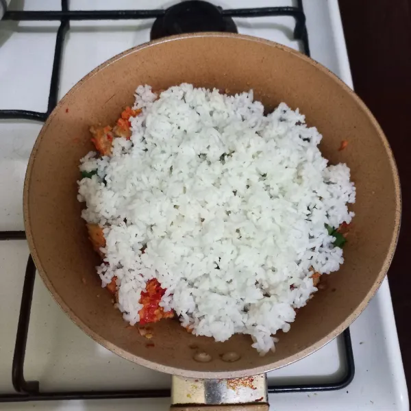 Masukkan nasi pada wajan, aduk rata.