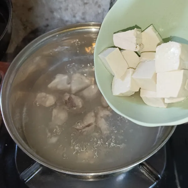 Masukkan potongan tahu ke dalam panci.