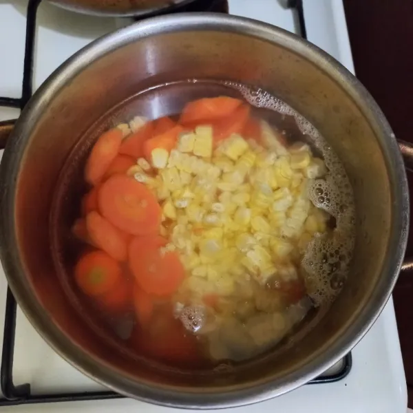 Didihkan air secukupnya pada panci, masukan irisan wortel dan pipilan jagung manis masak hingga setengah matang.
