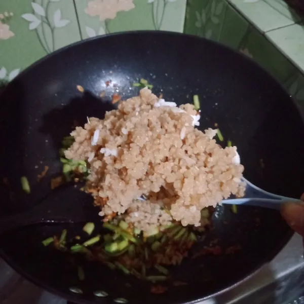Masukkan nasi tiwul dan nasi putih aduk hingga rata.