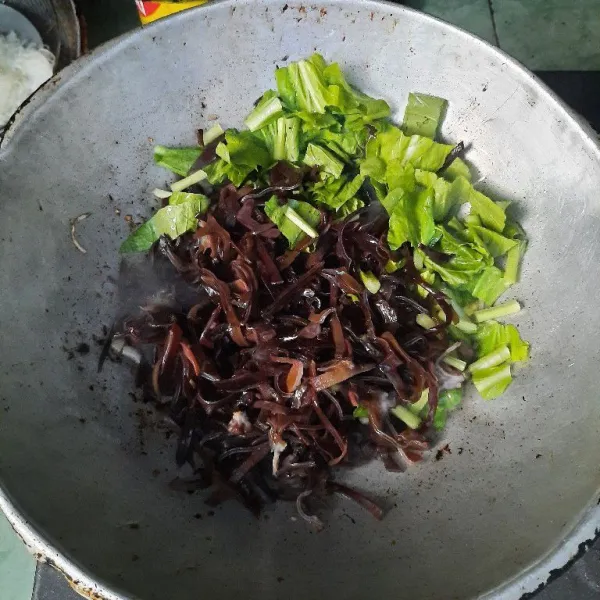 Masukkan jamur kuping dan sawi hijau, tumis sesaat sampai layu.