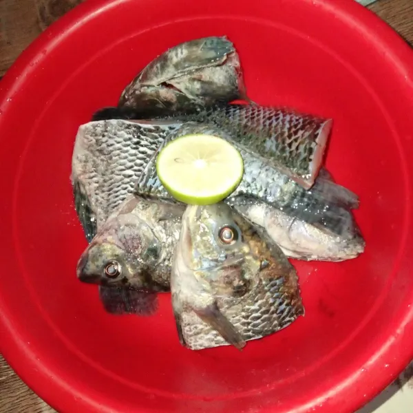 Siapkan ikan yang sudah dibersihkan, beri garam dan irisan jeruk nipis.