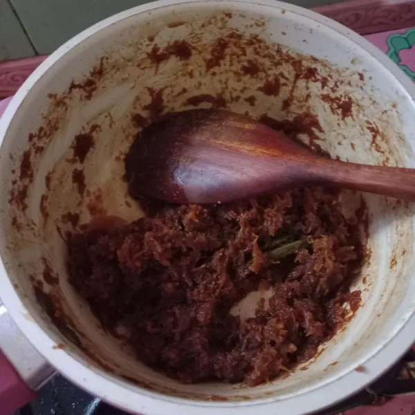 Setelah gula larut, masukkan kelapa parut, masak hingga air habis. Sisihkan