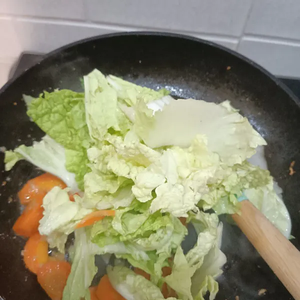 Sekarang tambahkan sawi putih, tumis sambil diaduk merata.