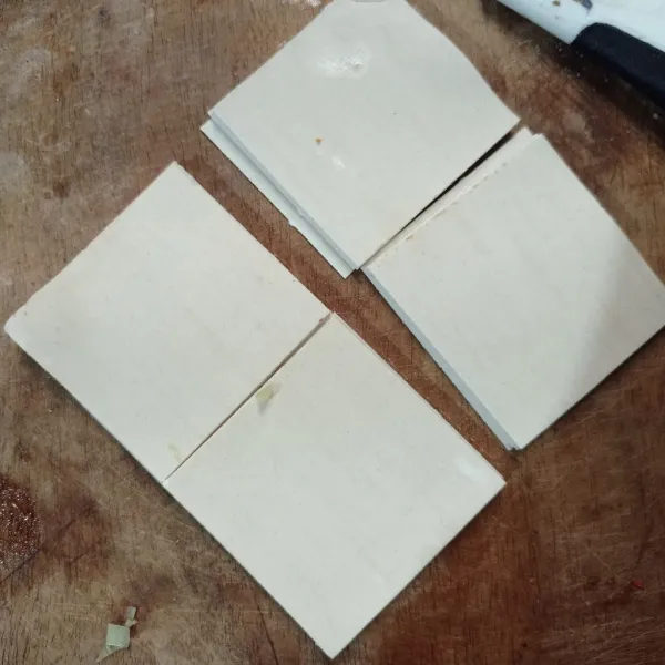 Siapkan kulit pangsit lalu potong jadi 4 bagian.