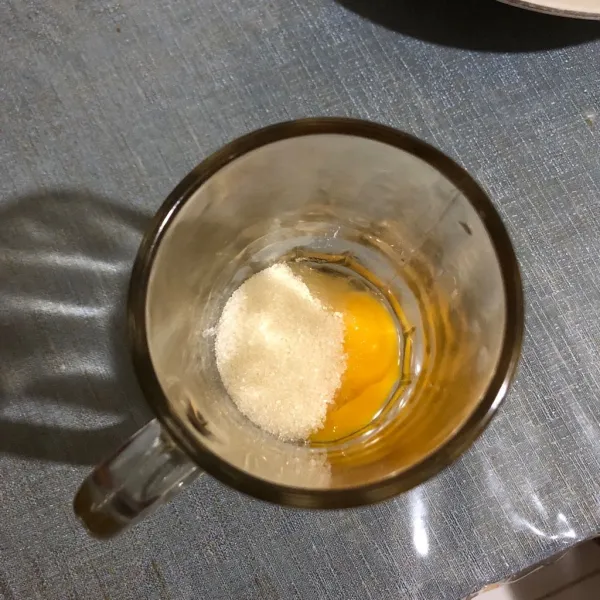 Masukkan telur dan gula ke dalam gelas.