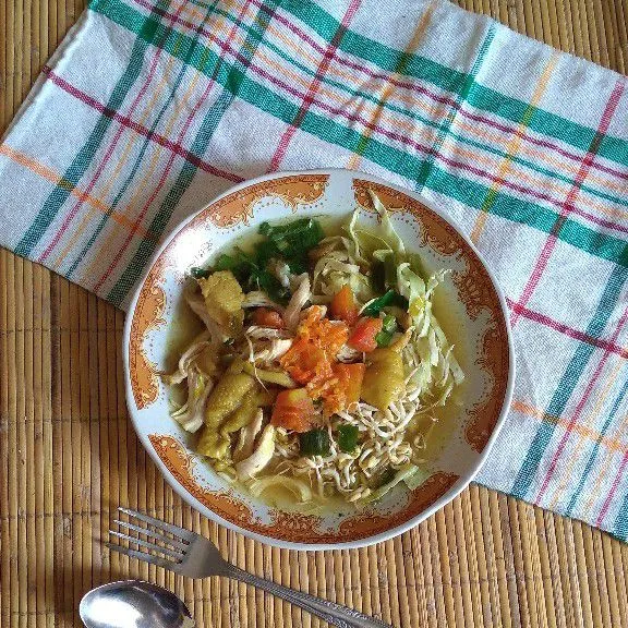Tata nasi, kubis, daun seledri, toge, ayam suwir, sambal di piring setelah itu siram dengan kuah soto.
