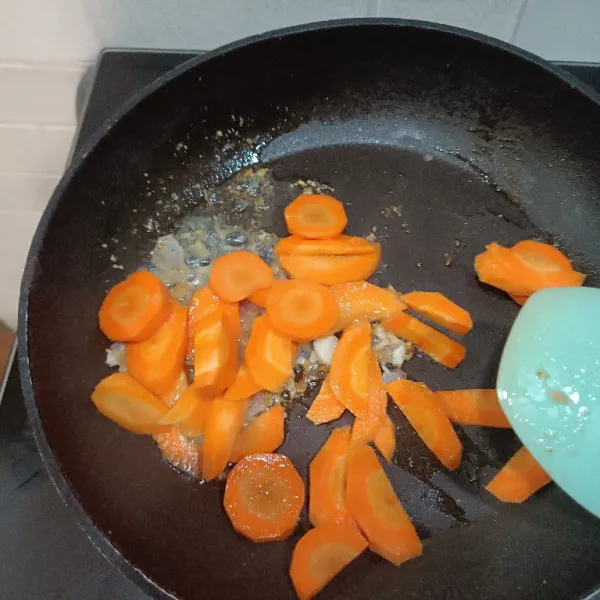 Masukkan wortel dan tumis sebentar sampai warna agak terang.