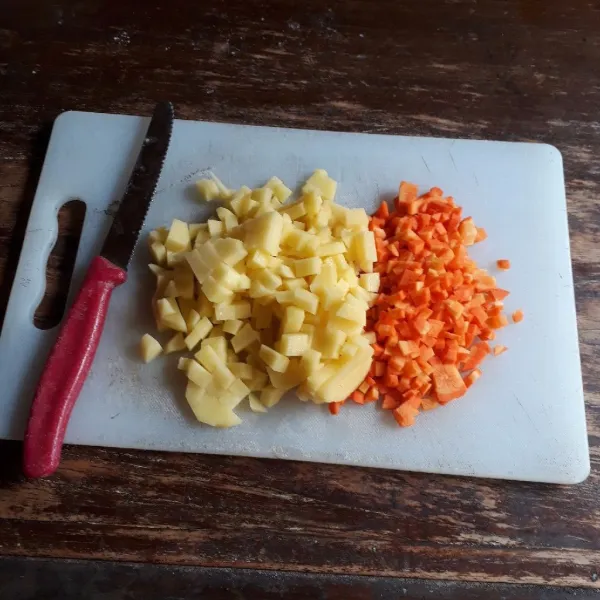 Kupas dan potong dadu kecil wortel dan kentang.