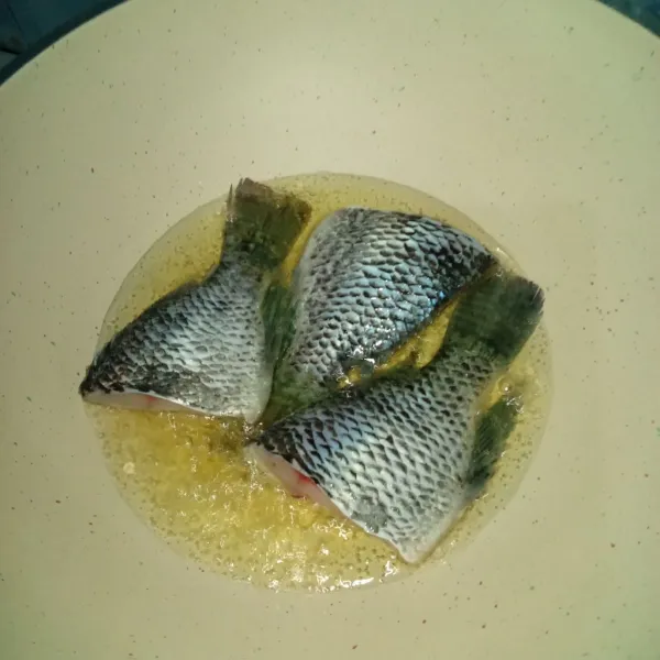 Goreng ikan, yang sudah dibersihkan dan dikasih air jeruk nipis dan garam.
