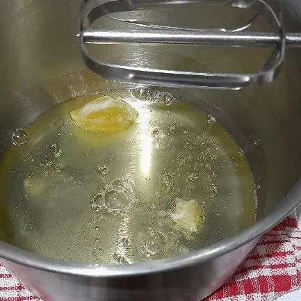 Dalam wadah, kocok putih telur dan emulsifier hingga rata