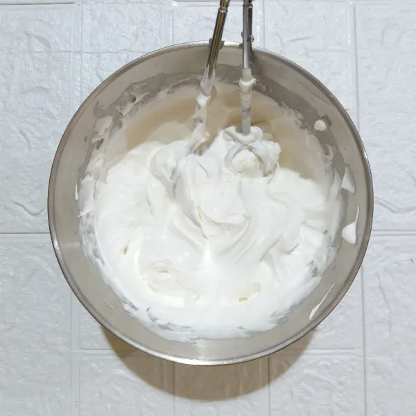 Mixer whipped cream bubuk dan air dingin suhu kulkas hingga mengembang kaku dan masukkan ke dalam piping bag