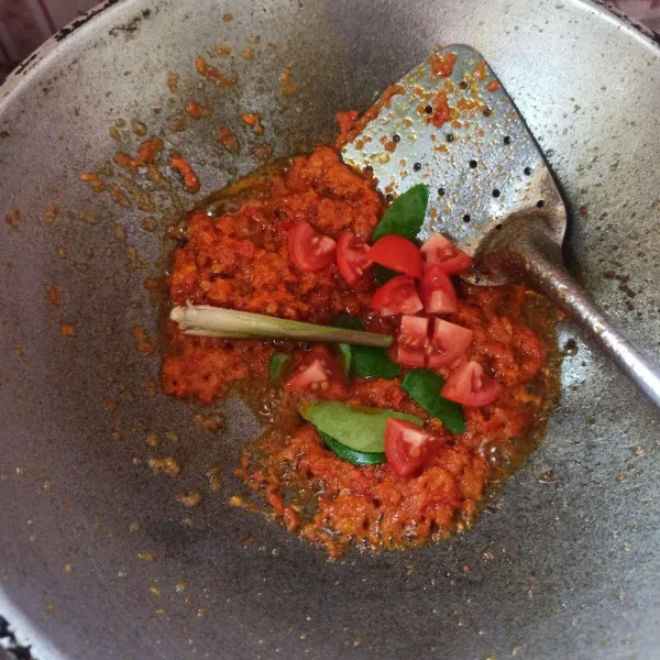 Tumis bumbu halus sampai harum dan matang. Setelah bumbu matang masukkan tomat, daun jeruk, dan serai kemudian tumis sampai layu.