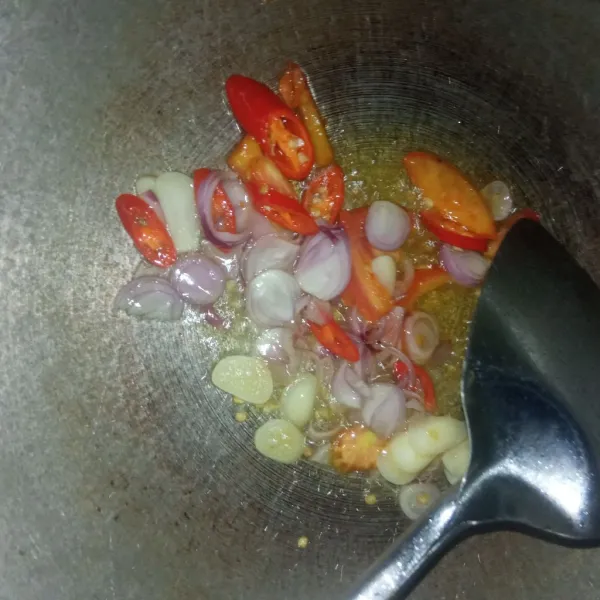 Panaskan minyak, tumis bawang, cabe dan tomat sampai layu.