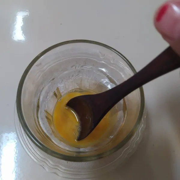 Siapkan gelas, kocok kuning telur.