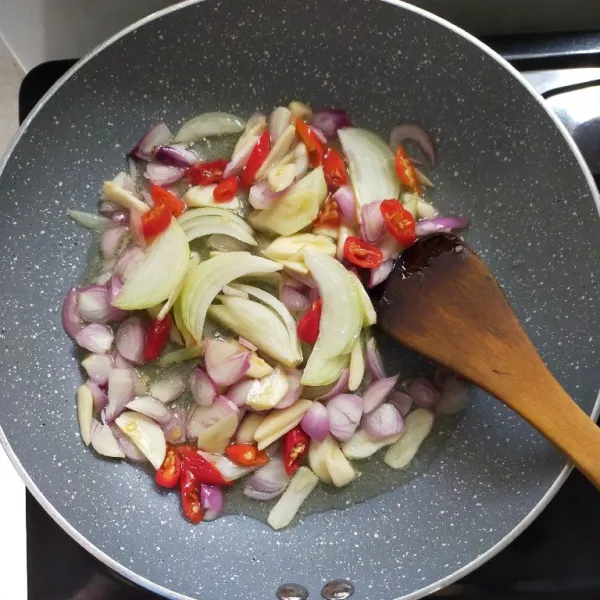 Panaskan minyak, tumis bawang merah, bawang putih, bawang bombay dan cabai rawit merah hingga harum dan layu.