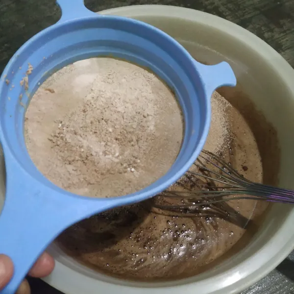 Tambahkan tepung terigu dan cokelat bubuk dengan cara diayak.
