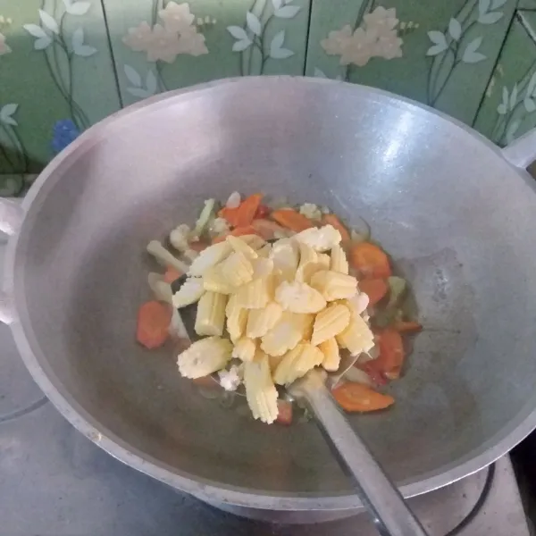 Masukkan baby corn dan air, masak hingga sayuran agak lunak.