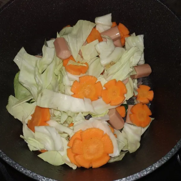 Tambahkan kubis, wortel dan sosis, aduk hingga layu.