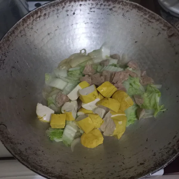 Masukkan potongan tahu dan irisan bakso ke dalam wajan.
