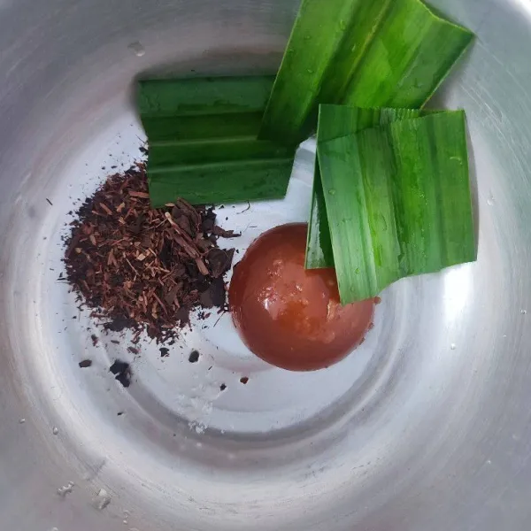 Masukkan daun teh, daun pandan, gula merah dan garam kedalam panci.