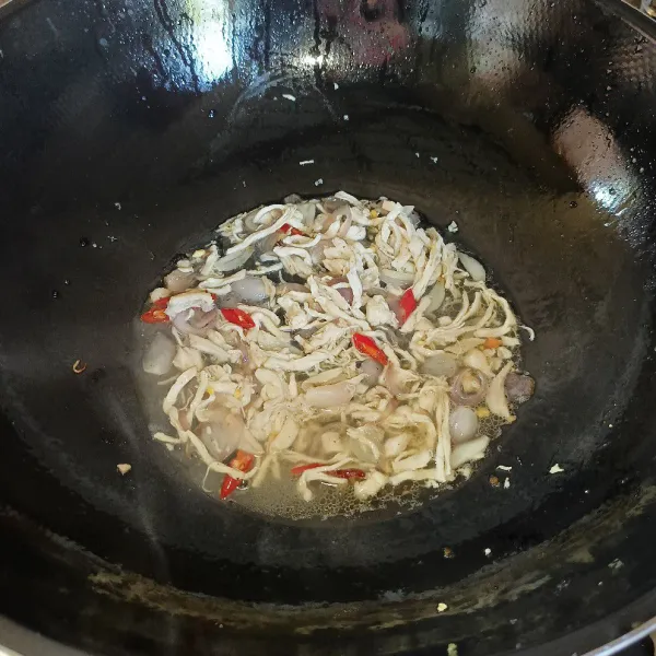 Masukkan ayam suwir dan aduk rata, lalu tuang air.